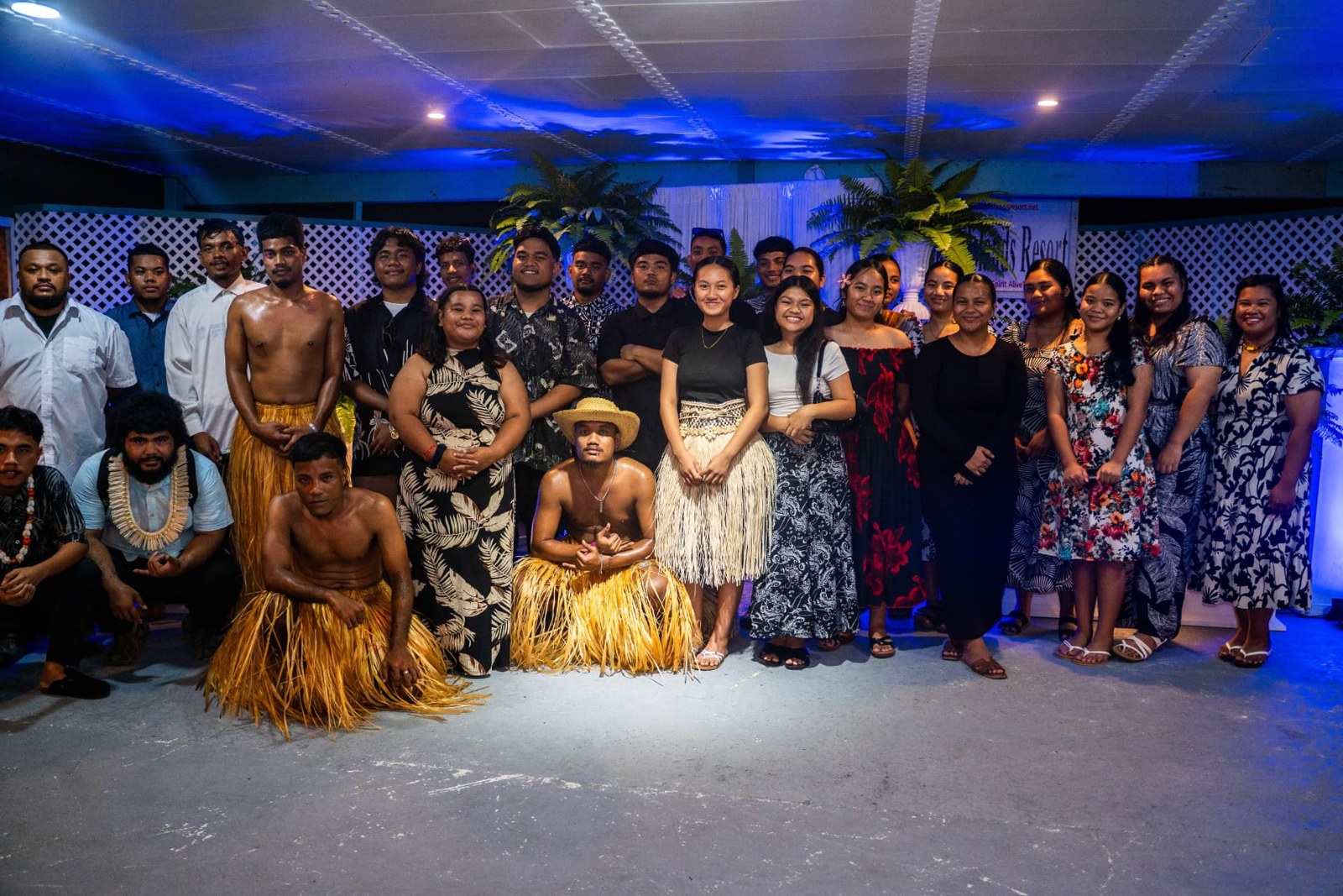 A group posing together in woven and contemporary dress at an event