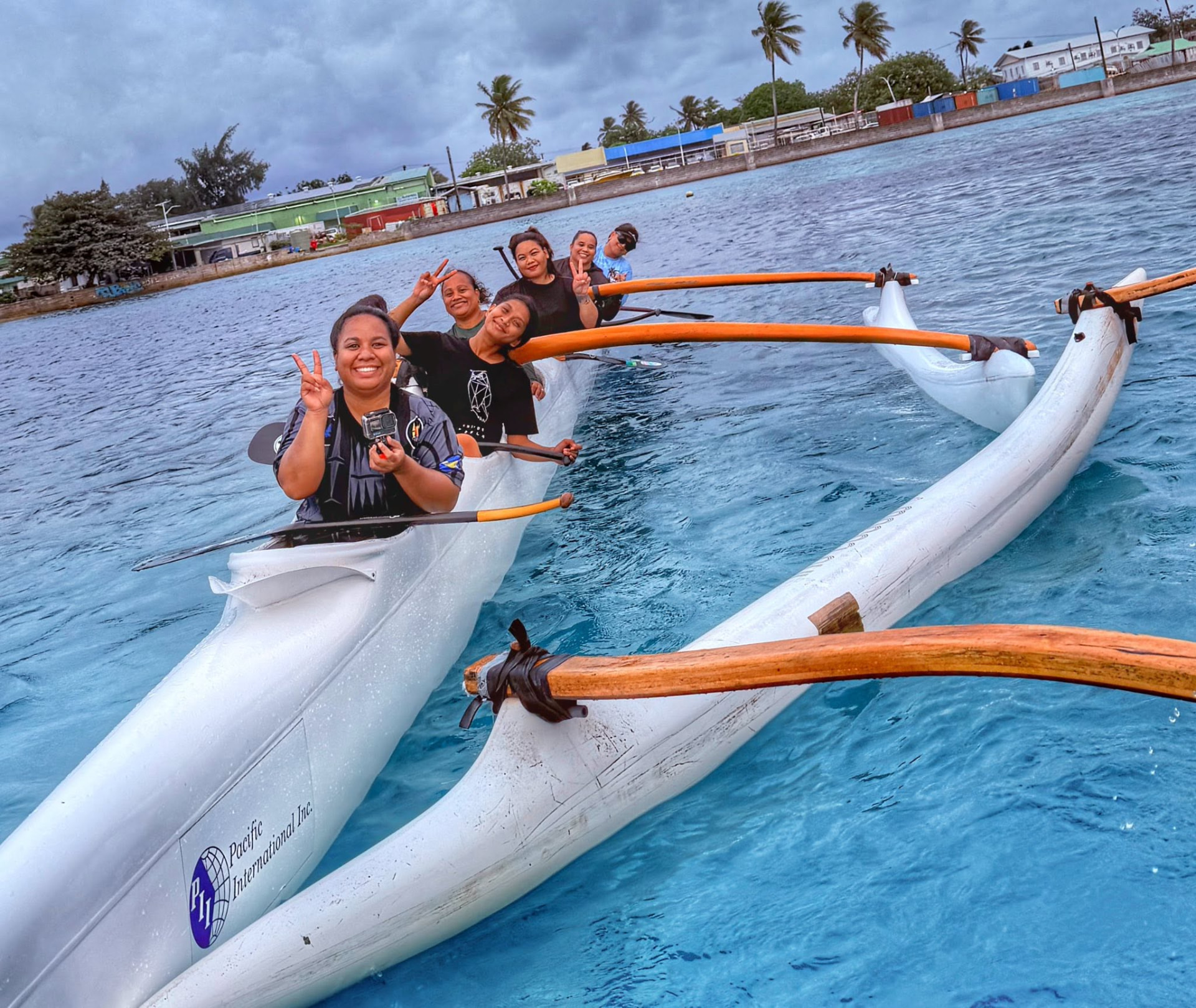 A group paddling an outrigger canoe on the lagoon